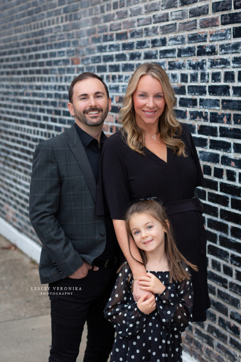 family portraits, wilmington nc family photographer, family of three, downtown wilmington, urban family portraits, children portraits, child, what to wear family session, what to wear black clothes, parents, loving family, sweet girl, family photography